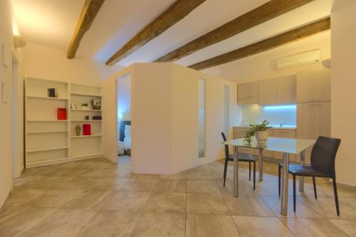 eine Küche und ein Esszimmer mit einem Tisch und Stühlen in der Unterkunft Imola Suites - Self Check-in in Imola