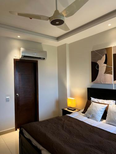 um quarto com uma cama e uma ventoinha de tecto em Modern 2 Bedroom Apartment with GYM&POOL em Lahore
