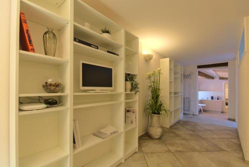 a living room with white shelves and a tv at Imola Suites in Imola
