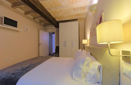 a bedroom with a large bed and a lamp at Imola Suites in Imola