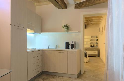 eine Küche mit weißen Schränken und einem Waschbecken in der Unterkunft Imola Suites - Self Check-in in Imola