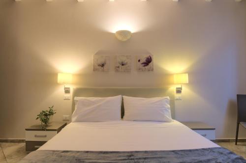 a bedroom with a white bed with two pillows at Imola Suites in Imola