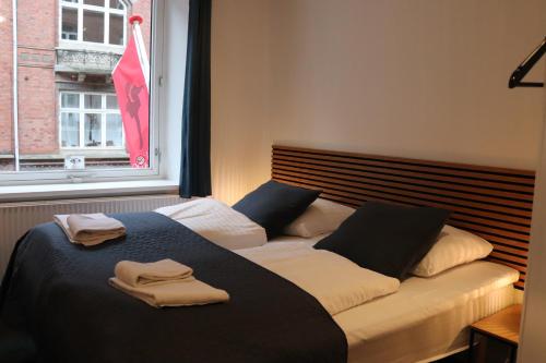 a bedroom with a bed with two towels on it at Milling Hotel Mini 11 in Odense