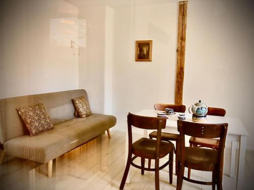 sala de estar con sofá y mesa con sillas en W Karkonoszach na Chacie #SAUNA # BILARD #LEŚNY PARK, en Wojcieszyce