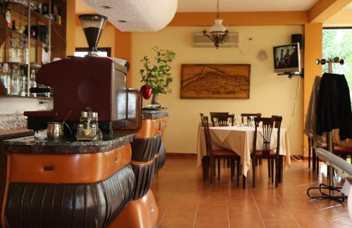 a restaurant with a bar with a table in the background at Hotel President in Golem