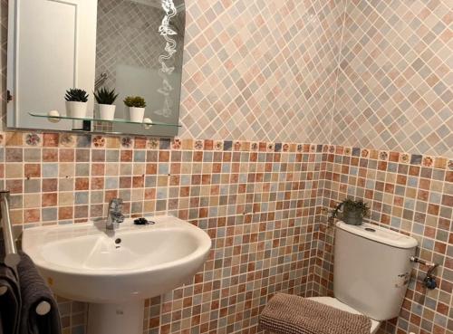 a bathroom with a sink and a toilet and a mirror at Casa Rio in Rojales