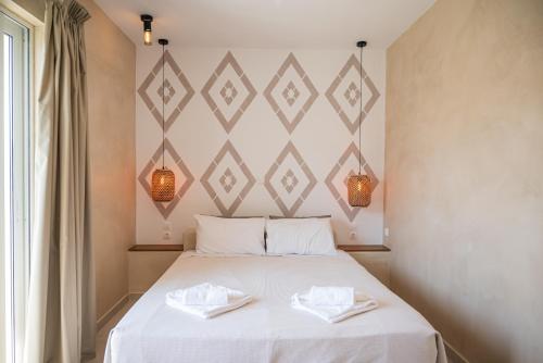 a bedroom with a bed with two towels on it at Atma Beach Rooms & Suites in Faliraki