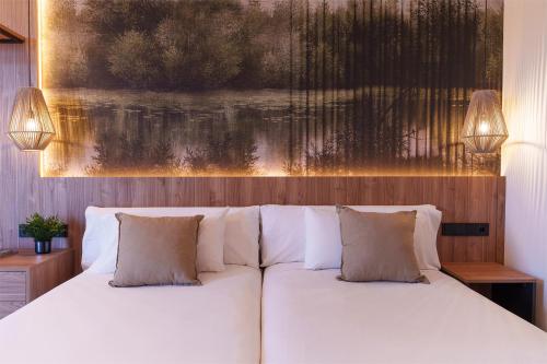 a bedroom with a white bed with two pillows at Spirit Hotel Ciudad de Burgos in Rubena