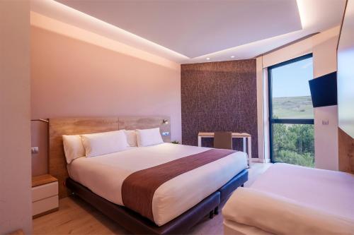 a bedroom with a large bed and a window at Spirit Hotel Ciudad de Burgos in Rubena