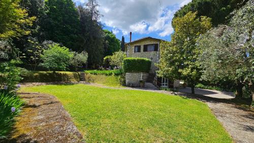 a large yard with a house in the background at La Piccola Rocca in Cetona