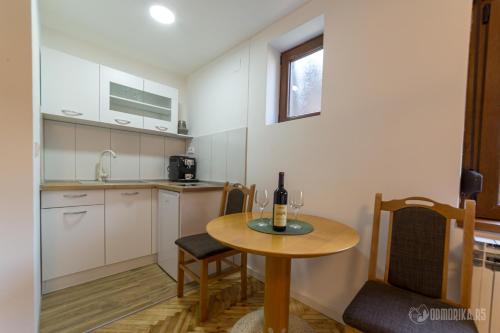 uma cozinha com uma mesa com uma garrafa de vinho em BB Sima 1 em Bajina Bašta