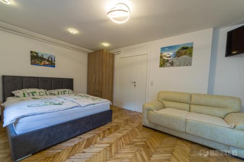 um quarto com uma cama e um sofá em BB Sima 1 em Bajina Bašta