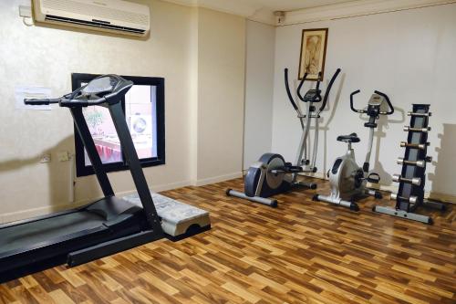 a gym with three exercise bikes and a television at Liberty Avenue Hotel in Doha