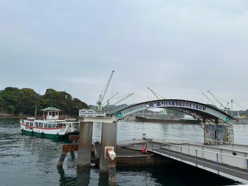 a bridge over a body of water with boats at しまの宿 Island Country Inn in Onomichi