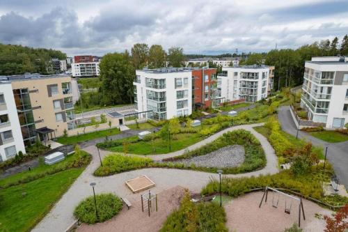 ein Park mitten in einer Stadt mit Gebäuden in der Unterkunft Kolmio Keskuspuiston lähellä in Espoo