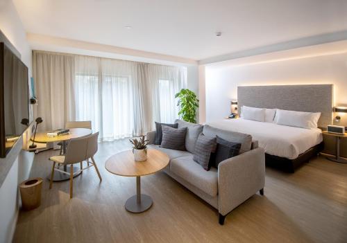 um quarto de hotel com uma cama, um sofá e uma mesa em INNSiDE by Meliá Madrid Valdebebas em Madri