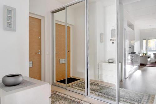 Kolmio Keskuspuiston lähellä في إسبو: غرفة بيضاء مع باب زجاجي ومرآة