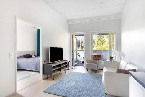 Kolmio Keskuspuiston lähellä في إسبو: غرفة معيشة بيضاء فيها سرير وتلفزيون