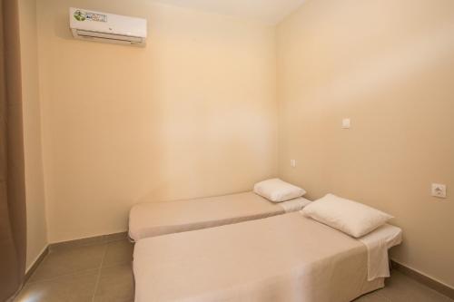 a room with two beds and a air conditioner at Atma Beach Rooms & Suites in Faliraki