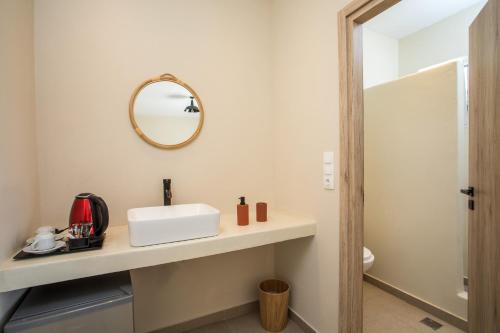 a bathroom with a sink and a mirror on the wall at Atma Beach Rooms & Suites in Faliraki