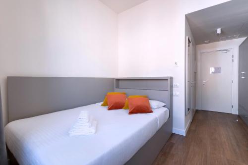 una camera da letto con un letto bianco e cuscini arancioni di S4 Stays a Firenze