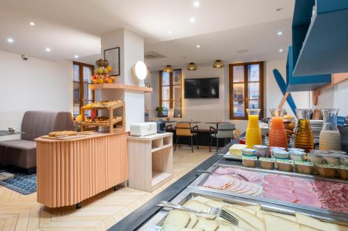 a lobby with a counter and a table with food at Hôtel du Palais de l'Isle in Annecy