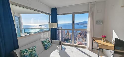 een woonkamer met een bank en een groot raam bij Highrise apartment with private terrace & sea views - 34th floor in Benidorm