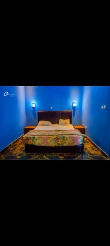 una camera con un letto con una parete blu di CIDMAT VILLA a Freetown