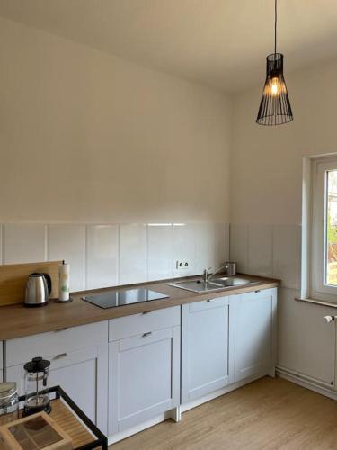 a white kitchen with a sink and a window at Schöne Erdgeschoss-Wohnung in Bremen in Bremen