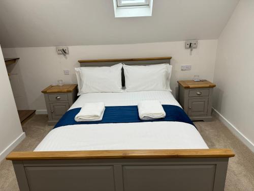 a bedroom with a bed with two towels on it at Wayfarers Lodge in Penzance