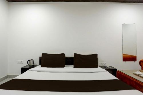 een slaapkamer met een groot bed met zwarte kussens bij OYO Flagship SAADAR HOTEL AND BANQUET in Kānpur