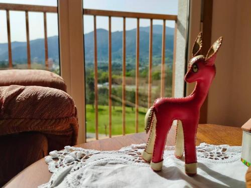 a toy goat sitting on a table in front of a window at Preciosas vistas en el corazón de la Riveira Sacra in Quiroga