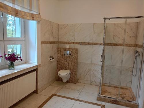 een badkamer met een douche en een toilet bij Oficerski Yacht Club in Augustów