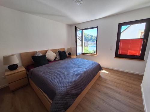 a bedroom with a bed and two large windows at Ferienhaus Take it easy in Traben-Trarbach