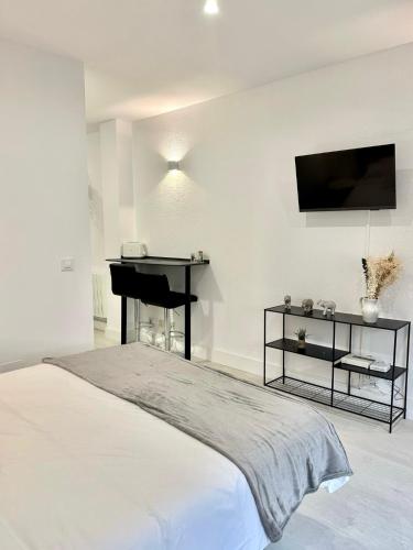 sypialnia z łóżkiem, biurkiem i telewizorem w obiekcie Apartamentos Val de Comillas w mieście Comillas