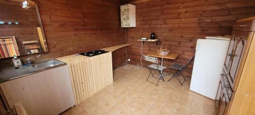 uma cozinha com um lavatório, uma mesa e um frigorífico em Du Gîte à la Terre em Saint-Gaudens
