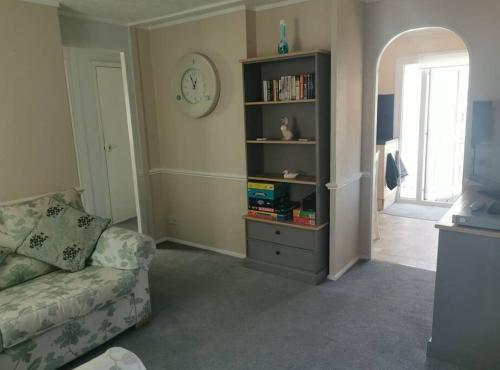 a living room with a couch and a book shelf at Fully refurbished holiday Chalet in withernsea in Withernsea