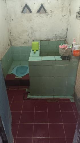 Khalisa Homestay في Komodo: حمام ذو بلاط أخضر مع مرحاض في الغرفة