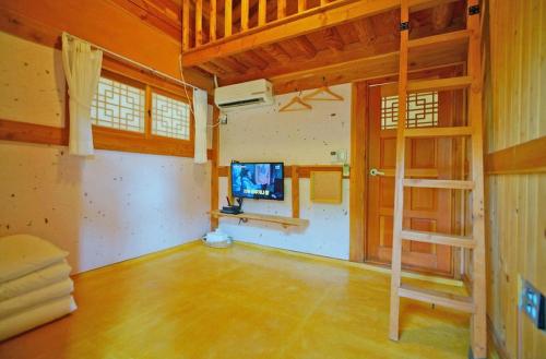 ein Wohnzimmer mit einem Etagenbett und einem TV in der Unterkunft Hanok Gotaek Goeul in Jeonju