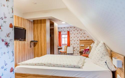 a bedroom with a bed and a tv in a room at Hotel Folklorehof in Chemnitz