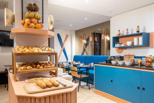 une boulangerie avec des armoires bleues et une table avec du pain dans l'établissement Hôtel du Palais de l'Isle, à Annecy