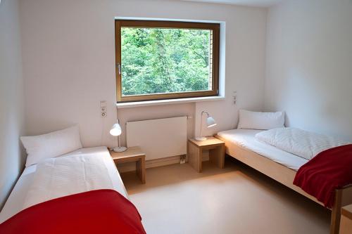 2 Betten in einem Zimmer mit Fenster in der Unterkunft Umwelt Bildungszentrum Berlin in Berlin