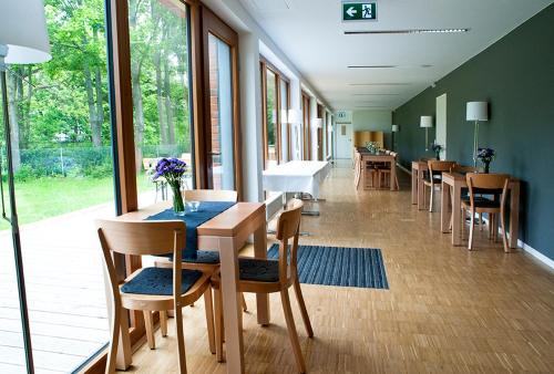 ein Esszimmer mit Tischen, Stühlen und Fenstern in der Unterkunft Umwelt Bildungszentrum Berlin in Berlin