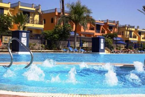 a swimming pool with a water fountain in it at Beach and golf 4 Bedroom Holiday Home in Maspalomas