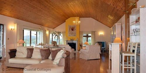 a living room with couches and a living room with at Cleggan 318 Atlantic Lodge in Cleggan