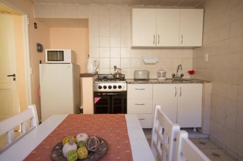 a kitchen with a table with a plate of fruit on it at Hualcupen Complejo in Copahue