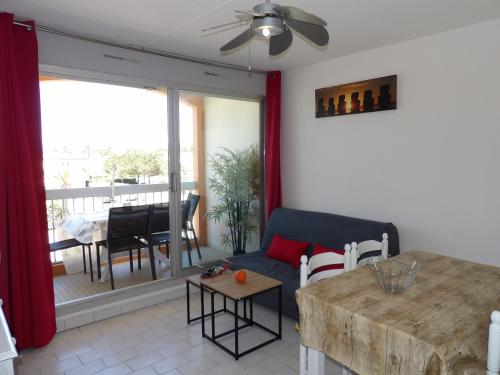 uma sala de estar com um sofá e uma mesa em Charmant appartement T2 avec Balcon em Saint-Cyprien