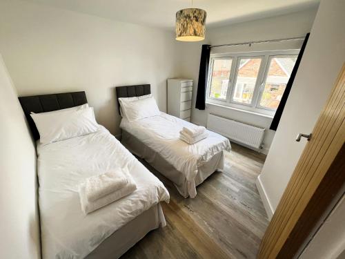 a bedroom with two beds and a window at Coach House Annexe in Sandown