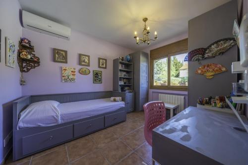 1 dormitorio con cama, escritorio y ventana en HomeHolidaysRentals Karisma - Costa Barcelona en Argentona