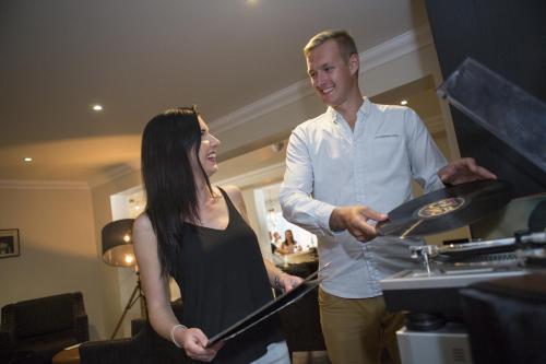a man and a woman standing next to a record player at Karma St. Martin's in St Martins